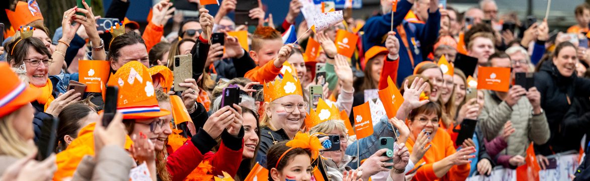 Publiek vooral gekleed in oranje langs de route tijdens Koningsdag in Emmen.