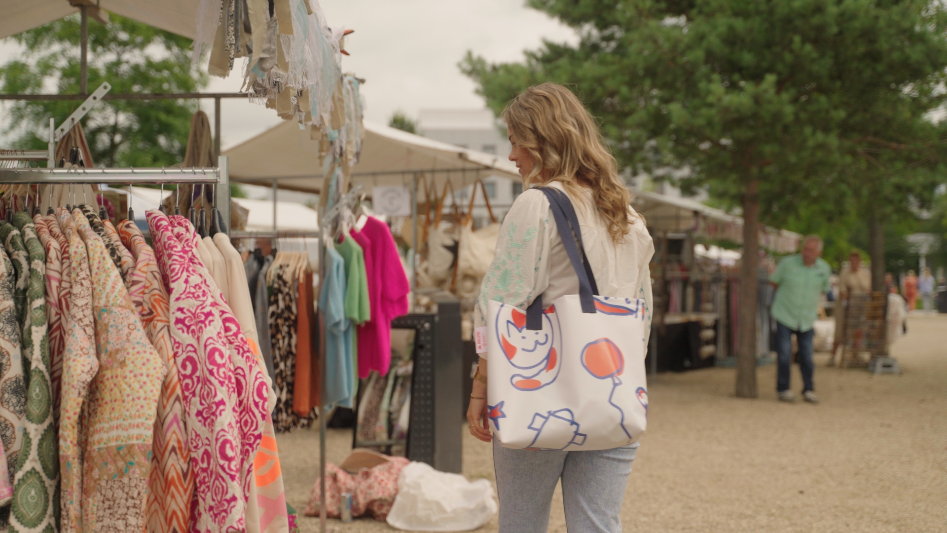 Vrouw loopt met een doedelzak om haar arm over de markt.